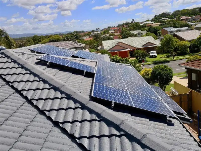 Solar panels on a grey tiled roof with hinterland views